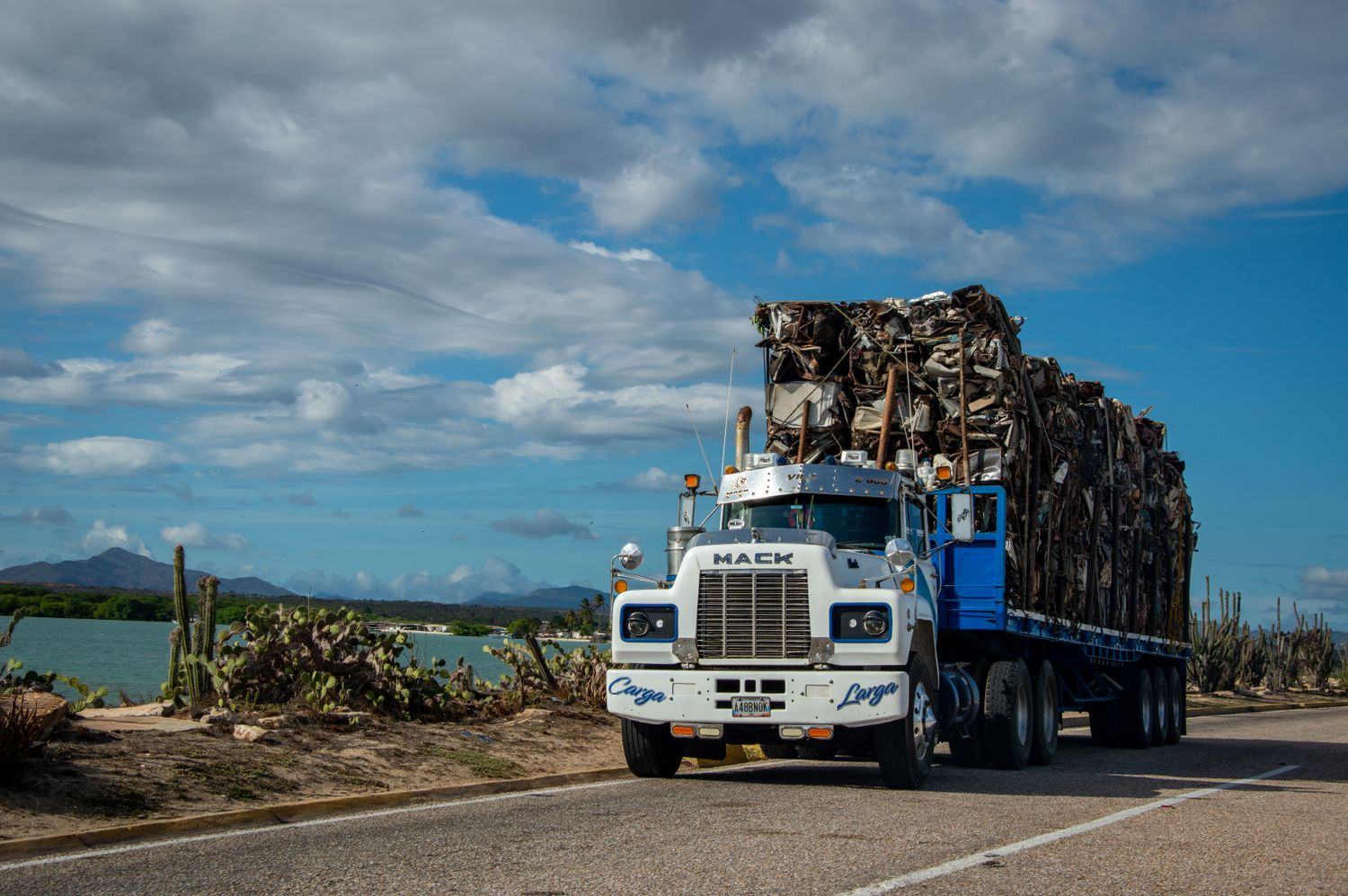 A flatbed truck loaded and strapped down on a highway