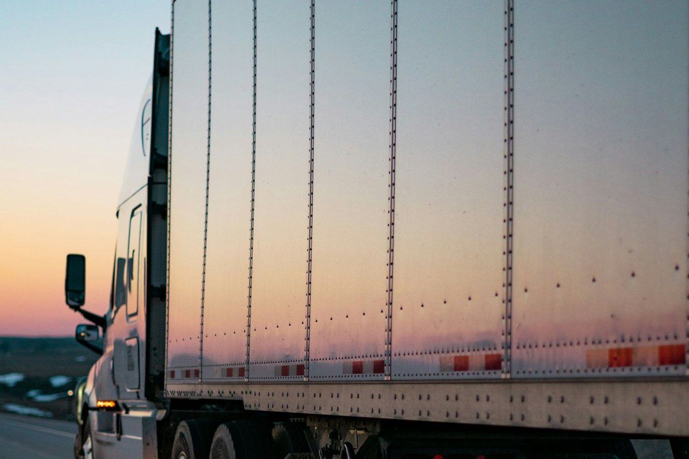 A dry van trailer loaded and rolling at dusk